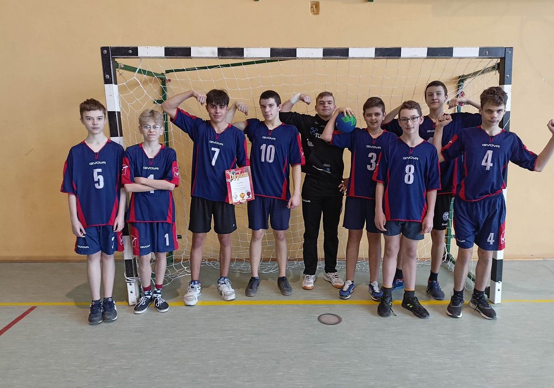 drużyna chłopców pozuje do zdjęcia na tle bramki