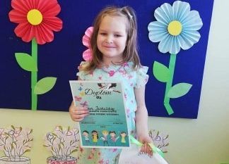 Dziewczynka z dyplomem i nagrodą.