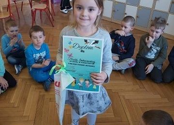 Dziewczynka z dyplomem i nagrodą.