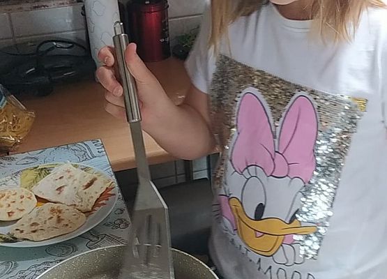 Uczennica piecze podpłomyki