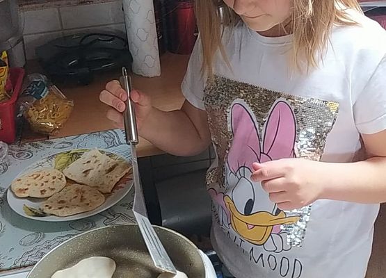 Uczennica piecze podpłomyki