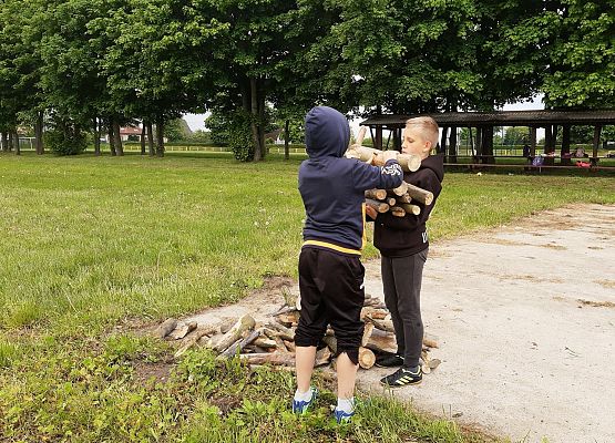 Uczniowie noszą drewno