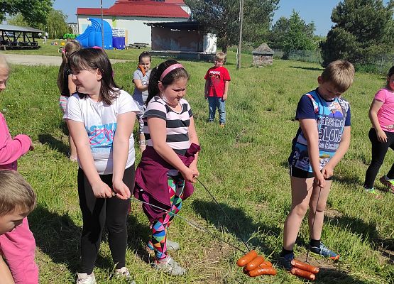 Uczniowie pieką kiełbaski nad ogniskiem