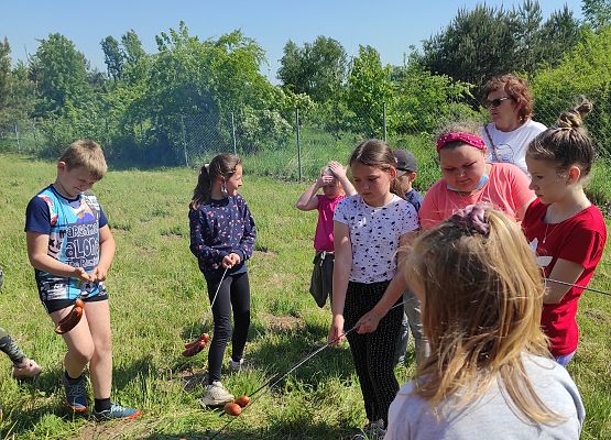 Uczniowie pieką kiełbaski nad ogniskiem