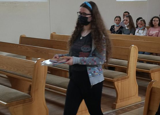 Uczennica niesie dar