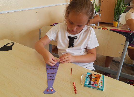 Uczennica wykonuje prezent z okazji Dnia Ojca