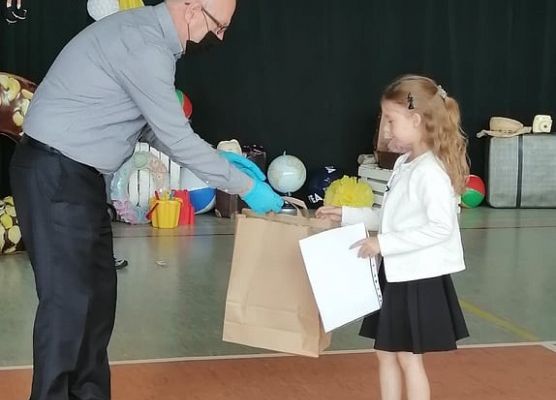 Dyrektor gratuluje dziewczynce