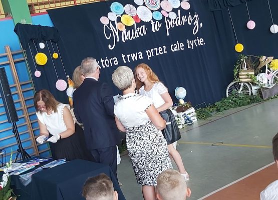 Uczennica odbiera świadectwo szkolne