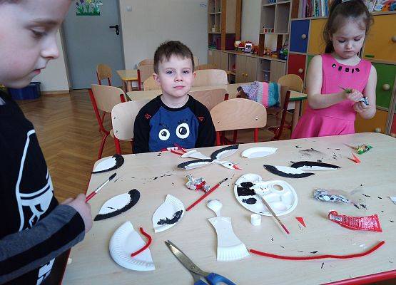 Przedszkolaki robią bociany z talerzyków papierowych