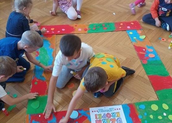 Dzieci naklejają kropki z ramkę.