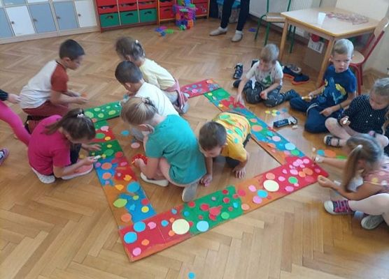 Dzieci naklejają kropki z ramkę.