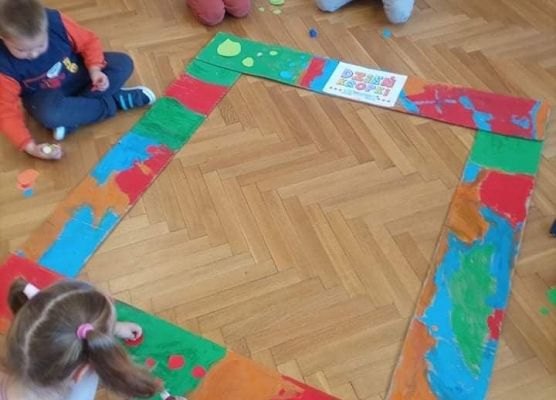 Dzieci naklejają kropki z ramkę.