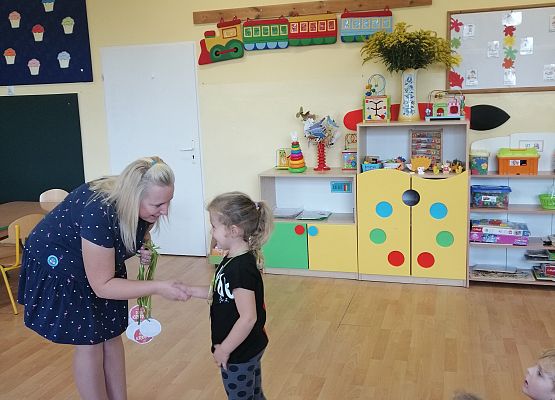 Nauczycielka rozdaje medale w kropki