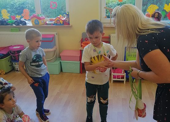 Nauczycielka rozdaje medale w kropki