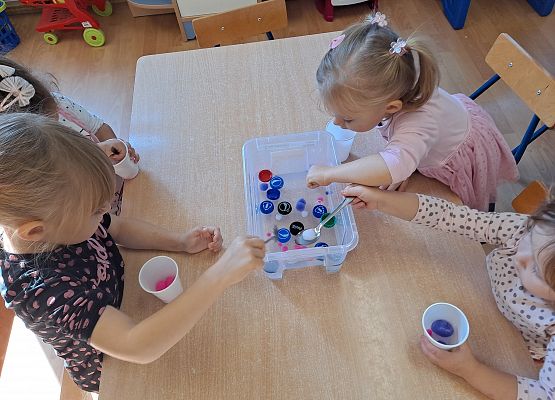 Dzieci próbują wyłowić z wody przedmioty