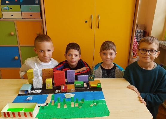 Uczniowie klasy trzeciej dumnie prezentują makietę