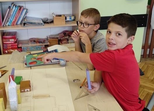 Uczniowie wyklejają makietę