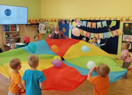 Dzieci tańczą z chusta i balonami