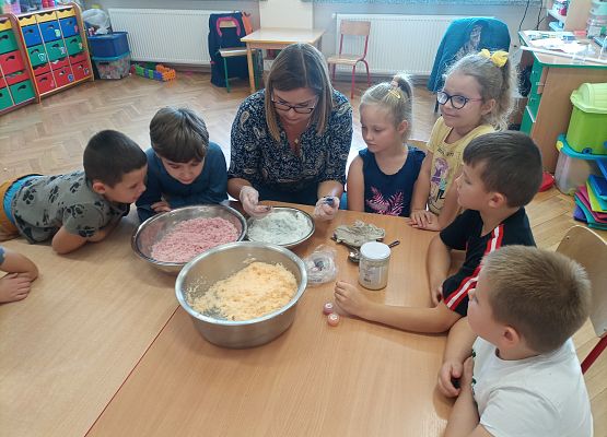 dzieci wspólnie z panią mieszają składniki