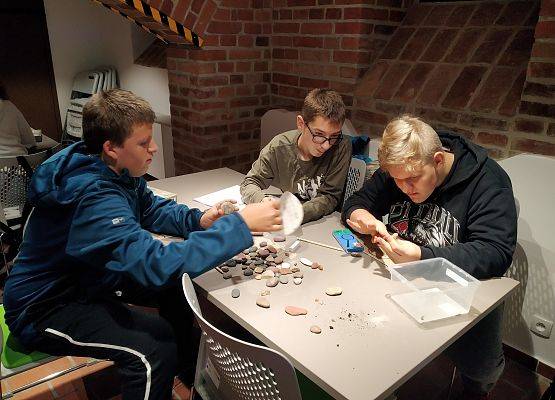 Chłopcy przyglądają się kamykom
