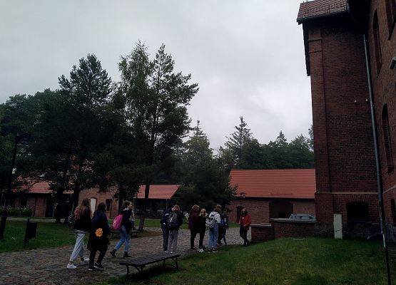 Uczniowie stoją przed budynkiem