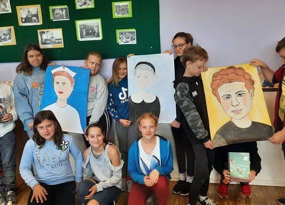 Grupa uczniów prezentuje portrety