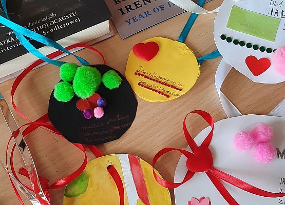 Na ławce leżą papierowe medale wykonane przez uczniów