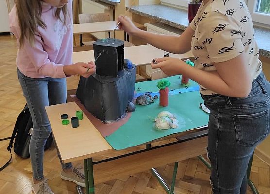 Uczennice malują elementy makiety