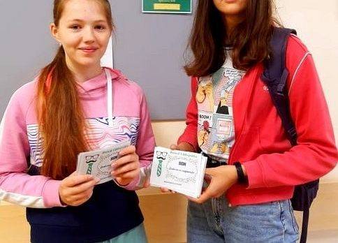 Przewodnicząca samorządu daje uczniowi boni
