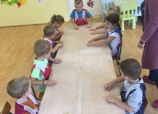 Dzieci klepią do rytmu rączkami po foli bąbelkowej