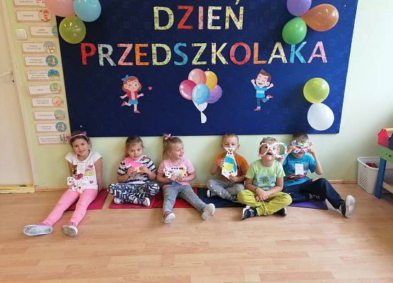 Dzieci siedzą na podłodze