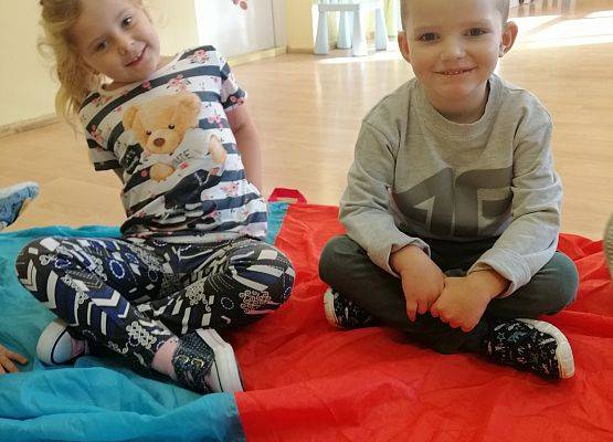 Dzieci siedzą na chuście