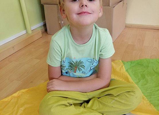 Chłopiec siedzi na chuście animacynej