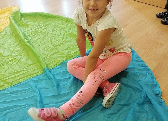 Dziewczynka siedzi na chuście animacynej