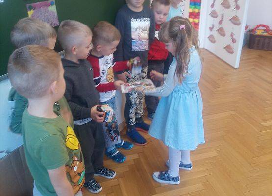 Dziewczynka wręcza prezent koledze