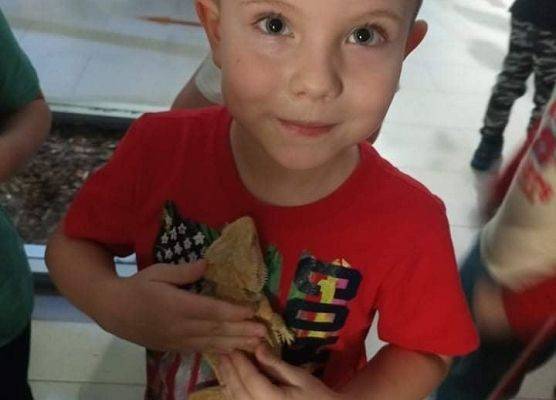 Chłopiec trzyma agamę brodatą