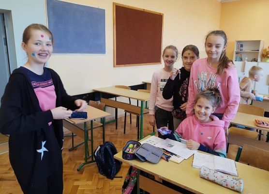 Uczennica rozdaje naklejki