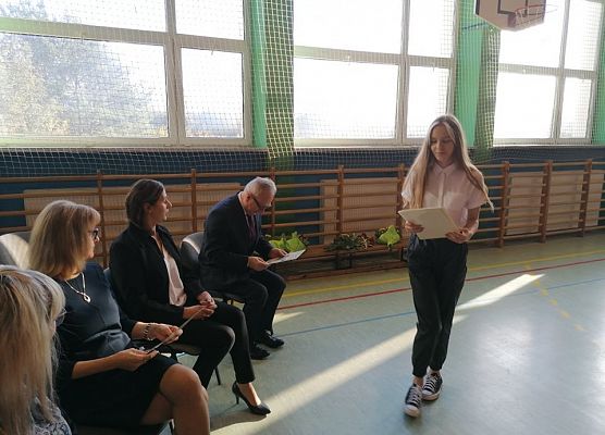Uczennica rozdaje upominki nauczycielom i pracownikom szkoły