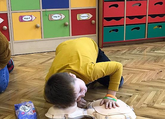 Chłopiec sprawdza czy poszkodowany (fantom) oddycha