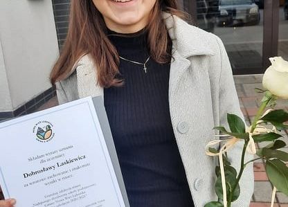 Nagrodzona uczennica z dyplomem i różą.