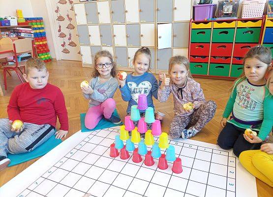 Dzieci ułożyły kolorową wieżę z kubków plastikowych