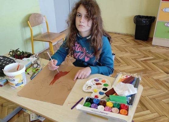 Uczennica maluje farbami