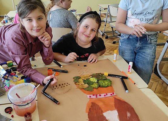 Uczennice ozdabiają plakat Borowej Ciotki