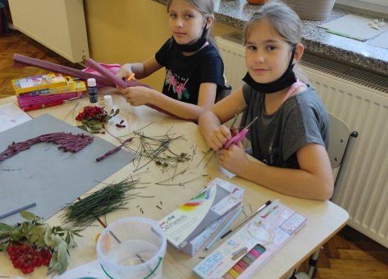 Uczennice ozdabiają plakat Borowej Ciotki