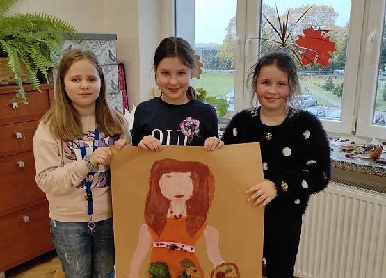 Uczennice prezentują wykonany przez siebie plakat Borowej Ciotki