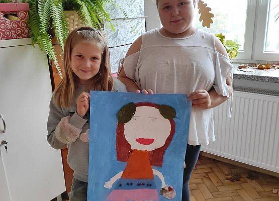 Uczennice prezentują wykonany przez siebie plakat Borowej Ciotki