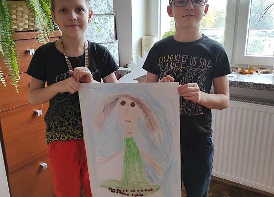 Uczniowie  prezentują wykonany przez siebie plakat Borowej Ciotki