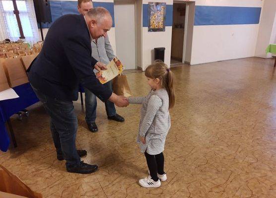 Dyrektor GOKu wręcza dyplom i nagrodę.