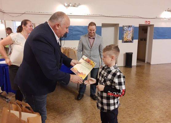 Uczeń odbiera nagrodę od dyrektora GOKu.