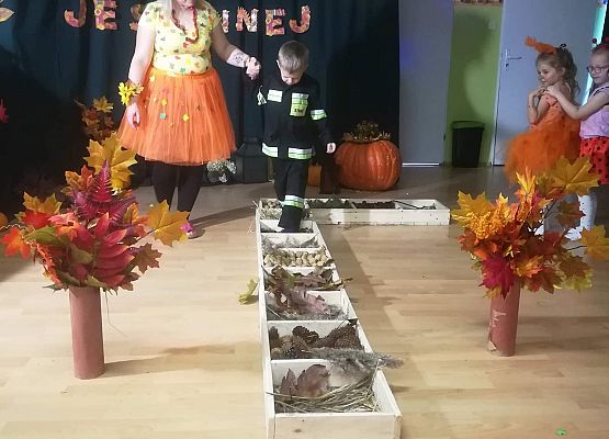 Chłopiec w asyście nauczycieli przechodzi przez ścieżkę sensoryczną